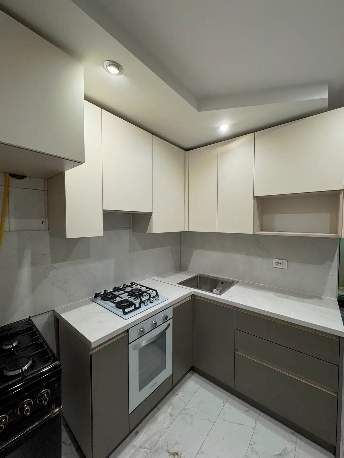 Светлая угловая кухня с интегрированными ручками